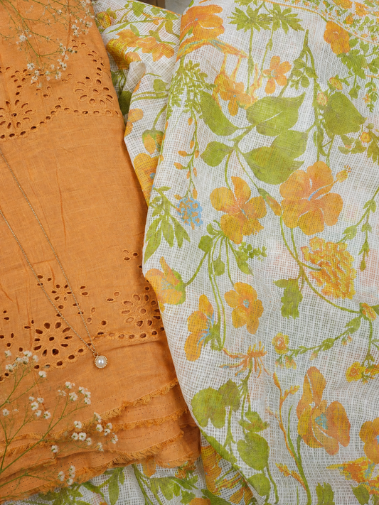 Close-up of orange fabric with intricate cut-out design and floral-patterned fabric.