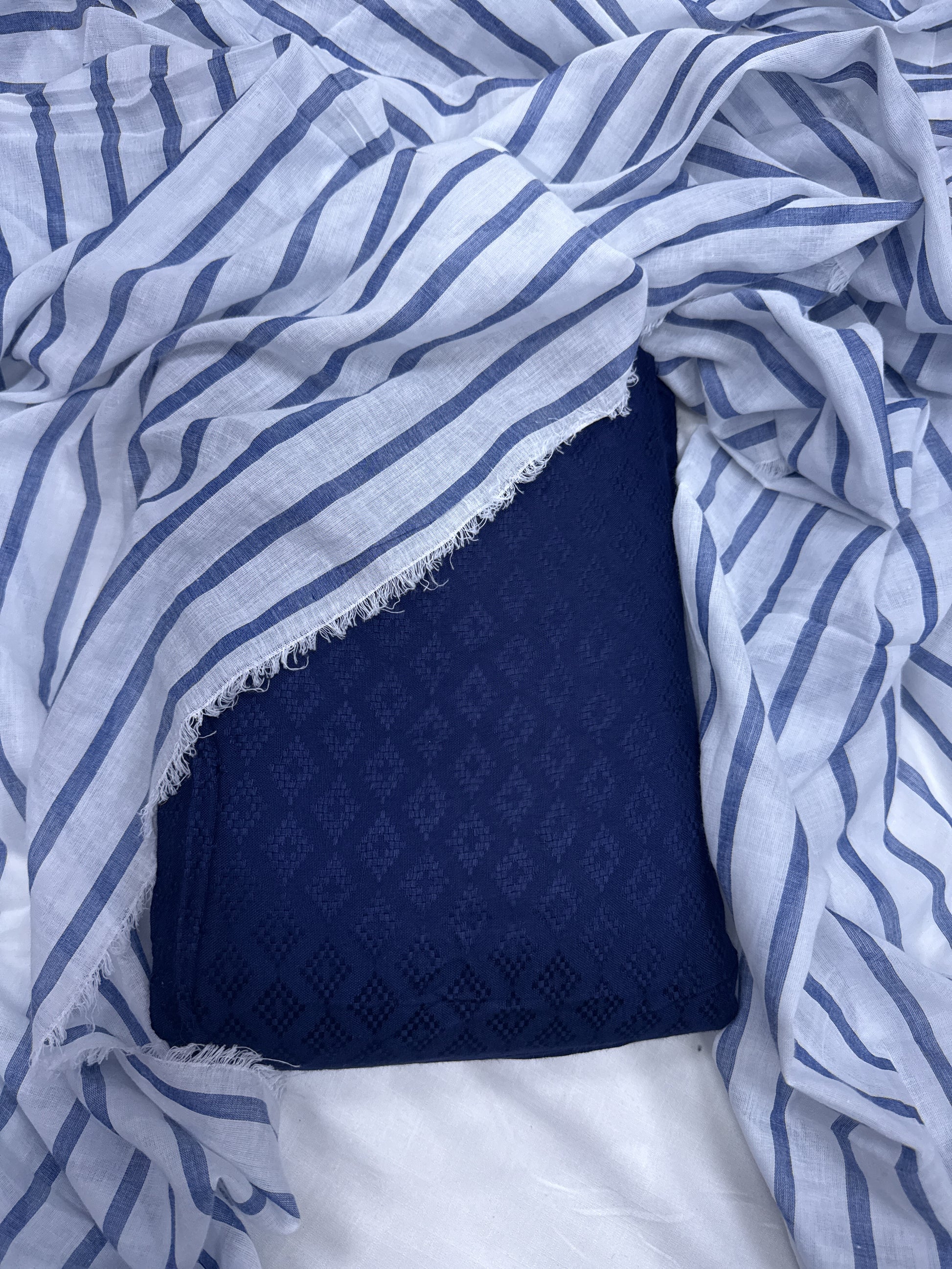 Blue and white patterned fabric with a textured navy square