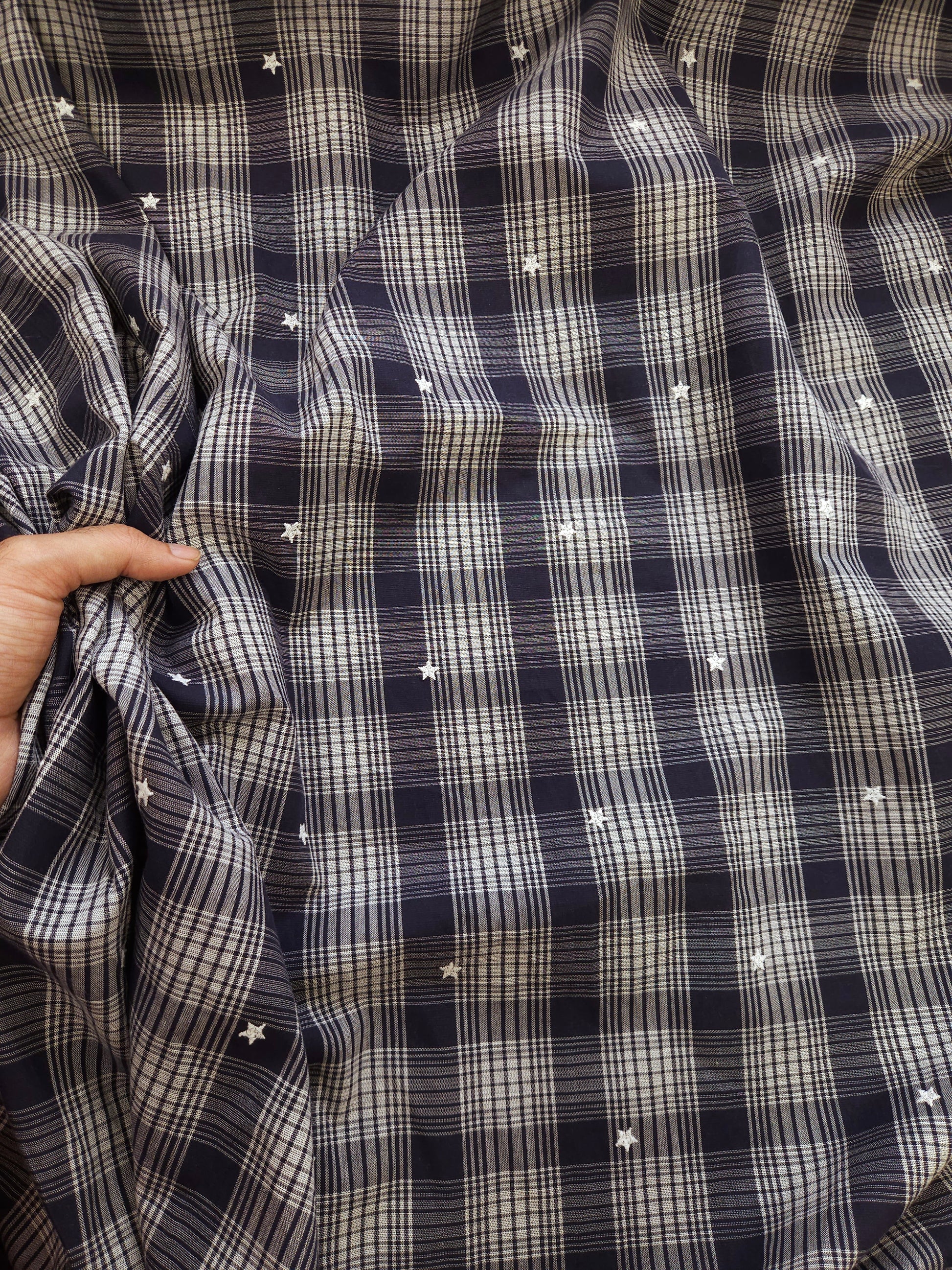 Close-up of a black and white checkered shirt with star patterns.