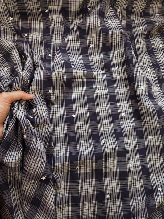 Close-up of a black and white checkered shirt with star patterns.